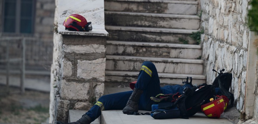 Φωτιά στην Αττική: Συγκλονιστική φωτογραφία - Αποκαμωμένος πυροσβέστης ξεκουράζεται σε πεζούλι